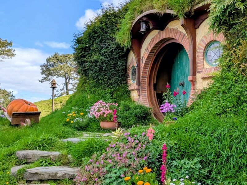 Explore the enchanting Hobbit house set in lush greenery at Hobbiton, Matamata, perfect for fantasy enthusiasts.